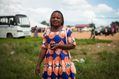 a smiling African woman in a colorful dress